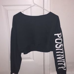 Green crop top with positivity on the left sleeve.